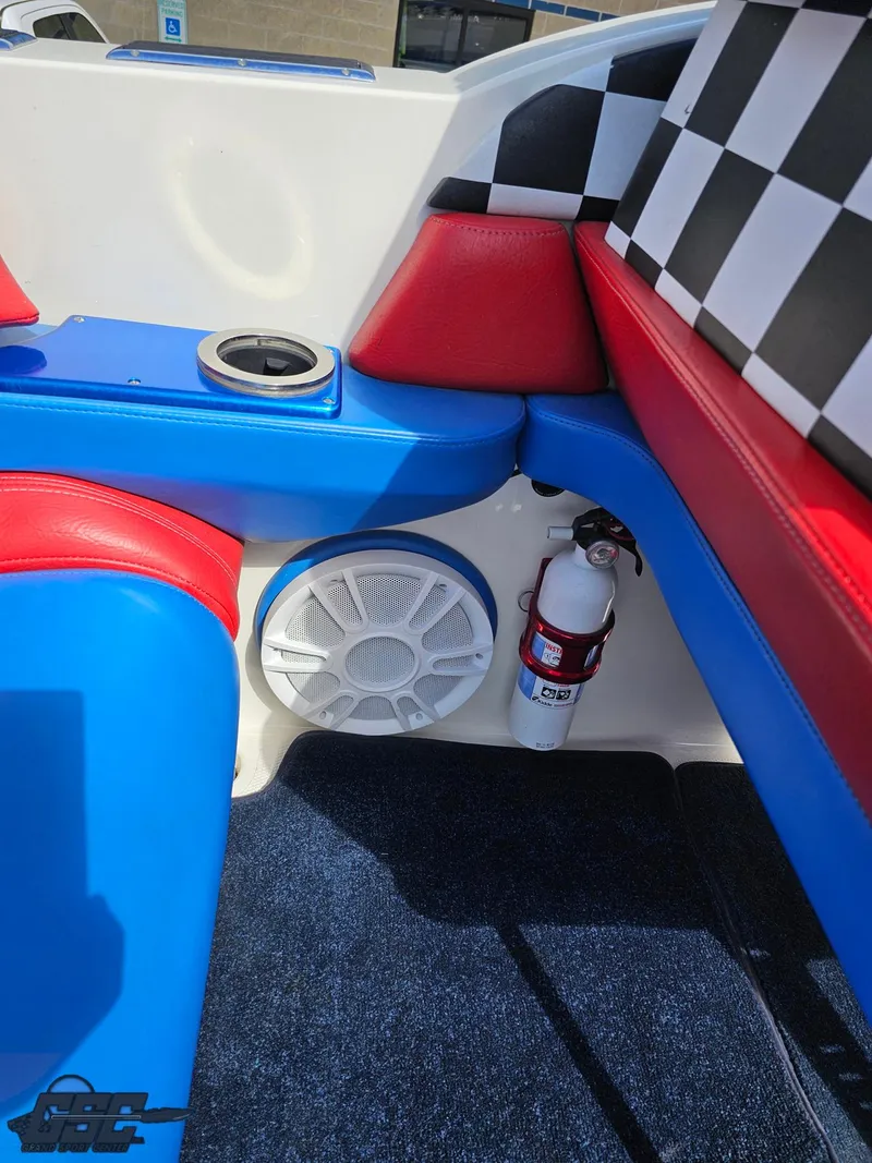 Slide: The Image of 2002 Black Thunder 460 SC boat interior with red, blue seating, speaker, and fire extinguisher. - 49