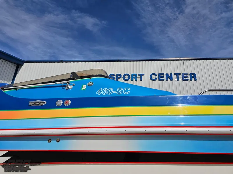 Slide: The Image of 2002 Black Thunder 460 SC boat at a sport center, vibrant blue and yellow design. - 9