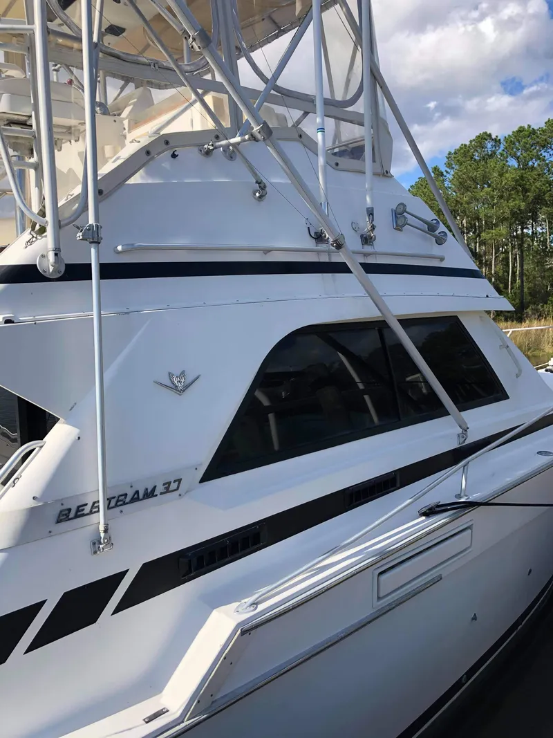 Slide: The Image of 1988 Bertram 37 Convertible yacht with sleek design and sturdy structure, docked outdoors. - 10