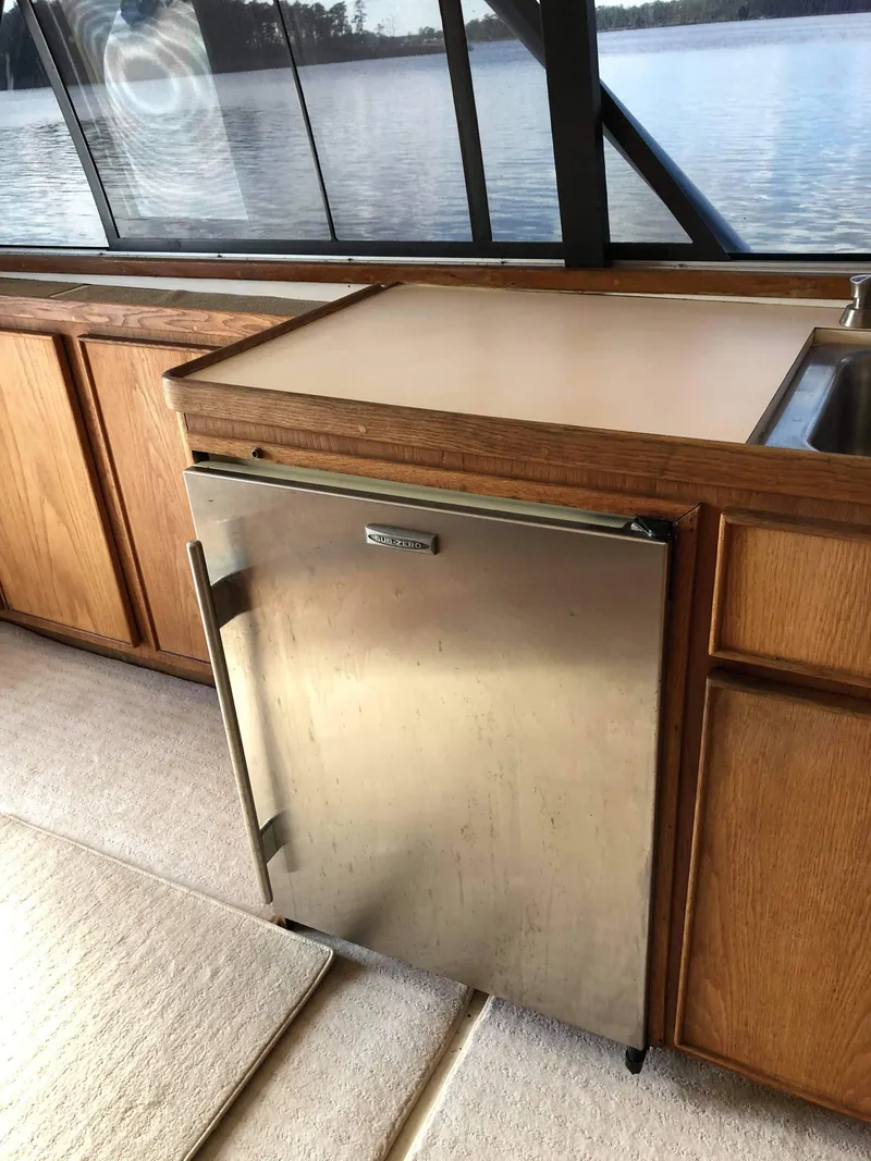 Slide: The Image of 1988 Bertram 37 Convertible yacht interior with wooden cabinets and stainless steel fridge. - 15