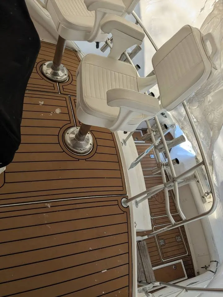 Slide: The Image of 1988 Bertram 37 Convertible boat deck with white chairs and wooden flooring. - 17
