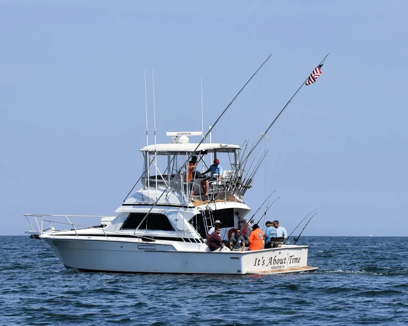 Slide: The Image of 1988 Bertram 37 Convertible boat with people fishing on open water. - 2
