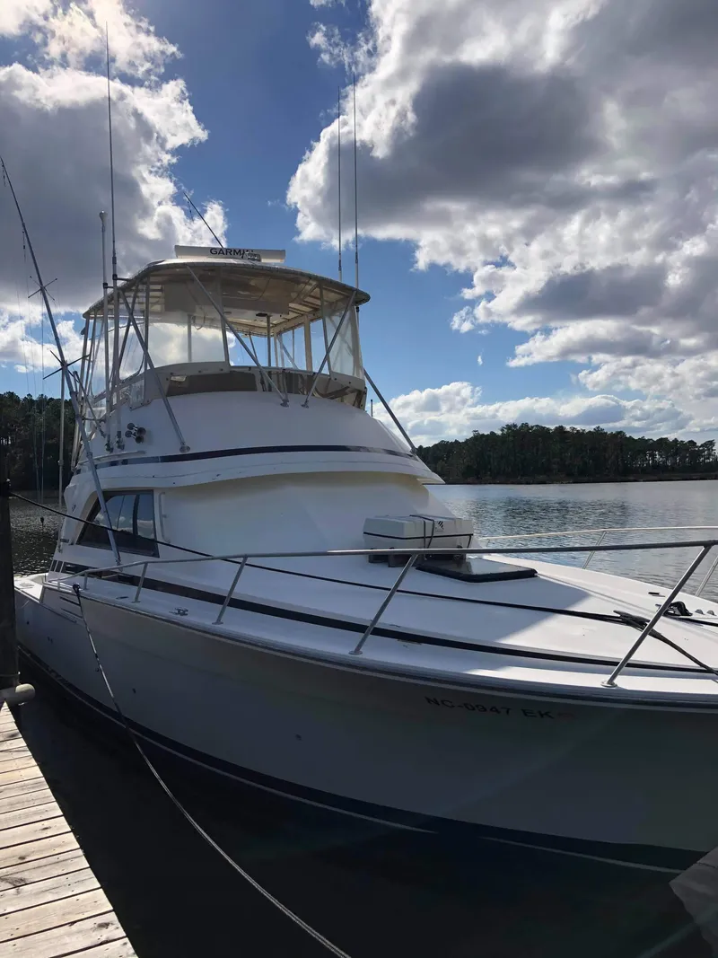 Slide: The Image of 1988 Bertram 37 Convertible yacht docked under a partly cloudy sky. - 5
