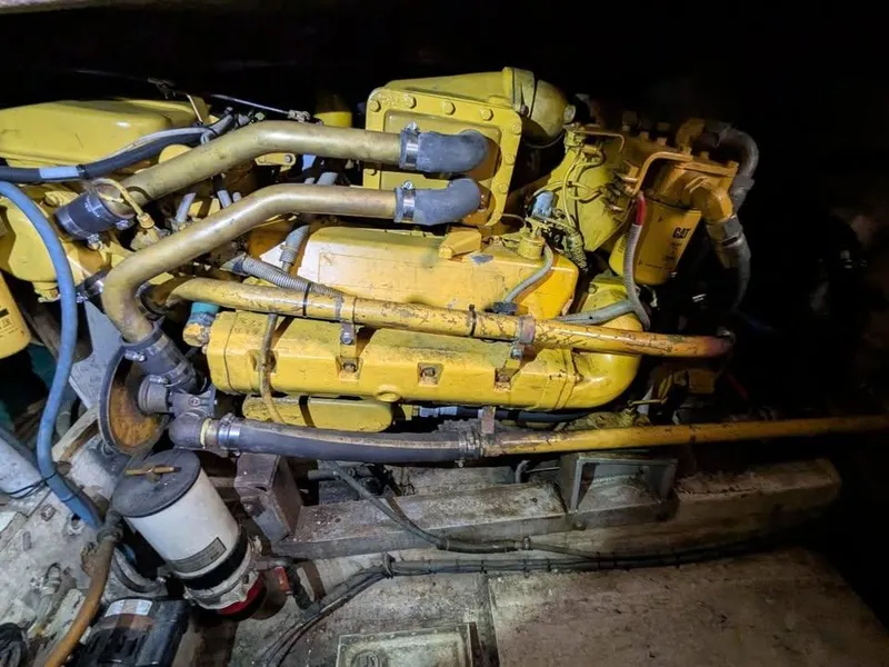 Slide: The Image of Engine room of a 1988 Bertram 37 Convertible boat, featuring a yellow engine. - 8