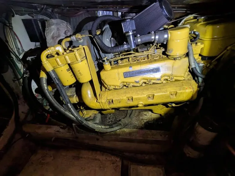 Slide: The Image of 1988 Bertram 37 Convertible engine, showcasing detailed mechanical components and yellow casing. - 9