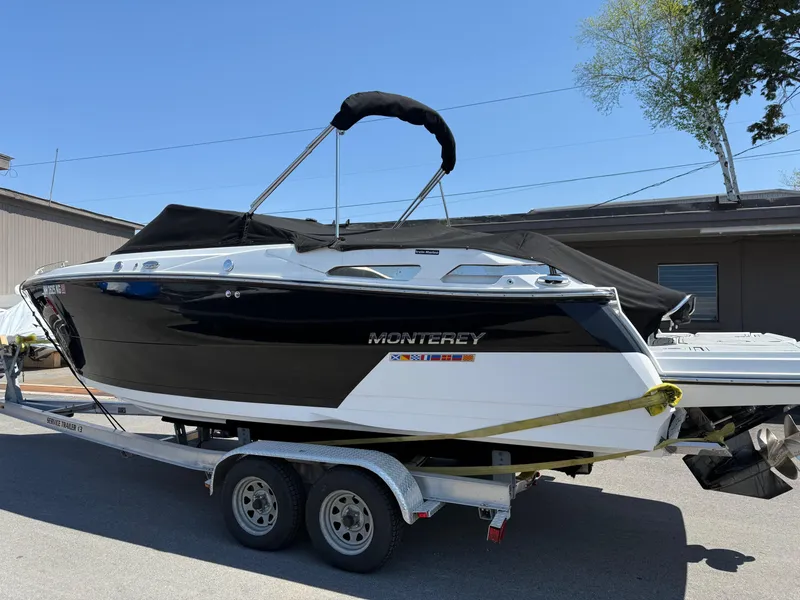 Slide: The Image of 2023 Monterey 258 Super Sport boat on trailer, black and white design, outdoor setting. - 1