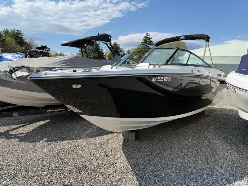 Slide: The Image of 2023 Monterey 258 Super Sport boat, black exterior, parked on gravel under a clear sky. - 2
