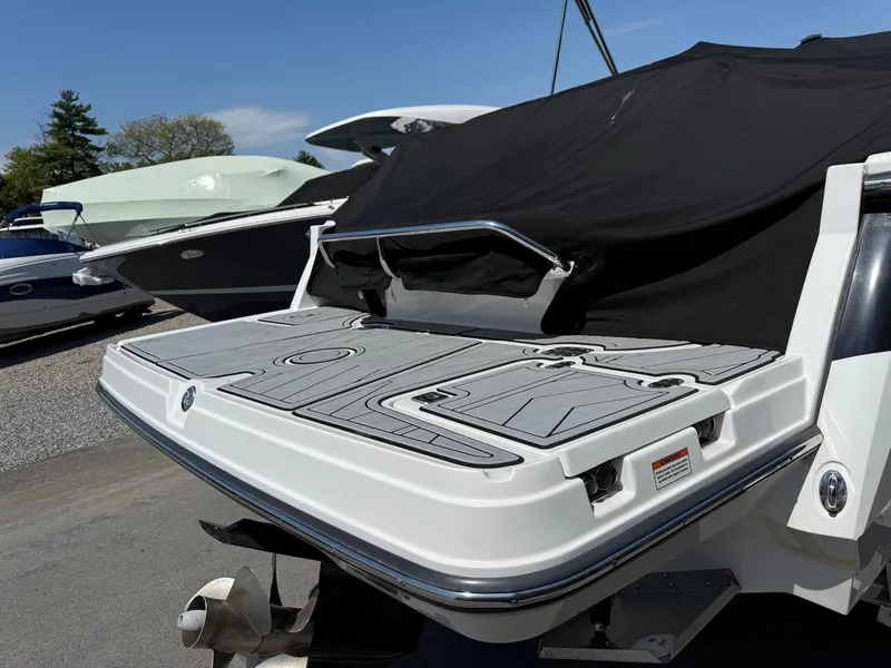 Slide: The Image of 2023 Monterey 258 Super Sport boat with sleek swim platform and black cover. - 20