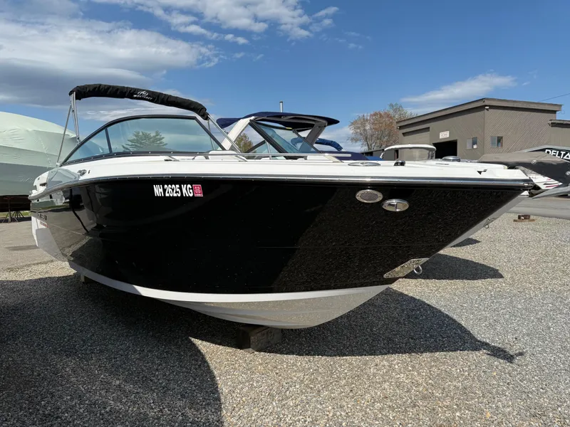 Slide: The Image of 2023 Monterey 258 Super Sport boat, black hull, parked outdoors on a sunny day. - 3