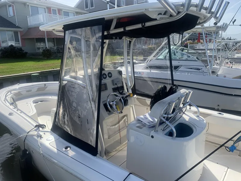 Slide: The Image of 2011 Pioneer 222 Sportfish boat with center console and protective enclosure, docked near waterfront homes. - 12