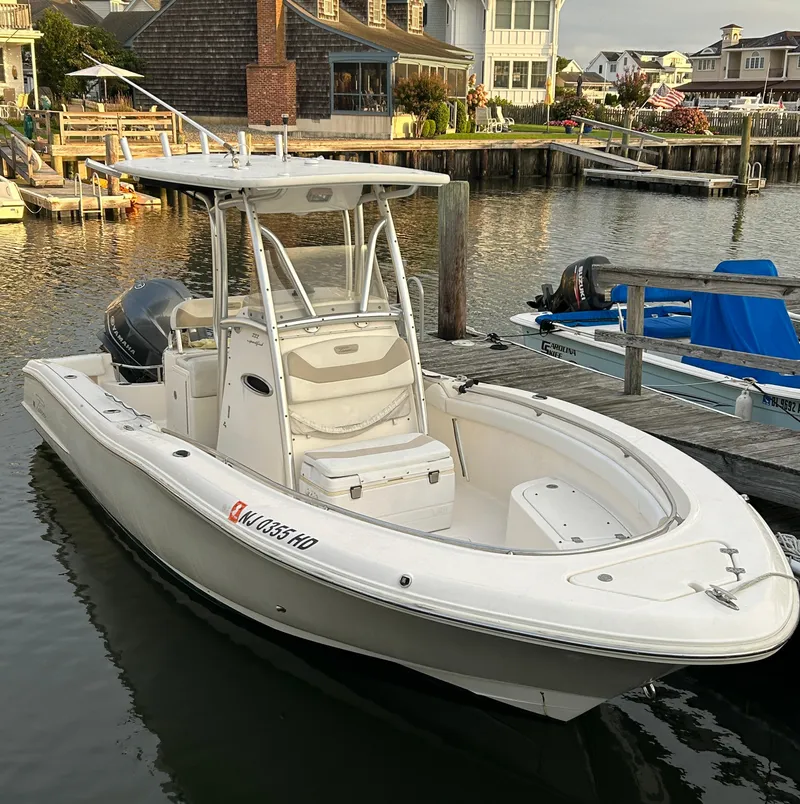 Slide: The Image of 2011 Pioneer 222 Sportfish boat docked in a marina, featuring a sleek white design. - 3