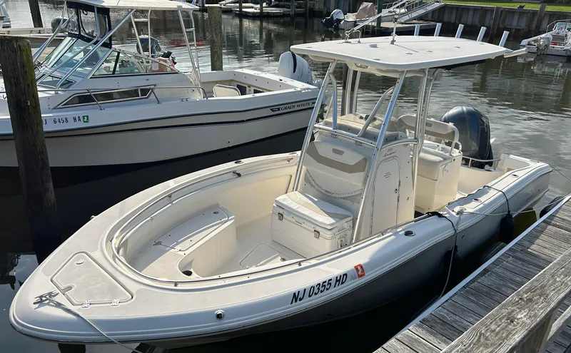 Slide: The Image of 2011 Pioneer 222 Sportfish boat docked at marina, featuring sleek design and spacious seating. - 4