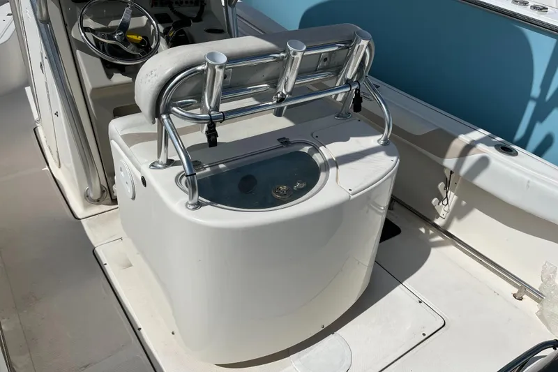 Slide: The Image of 2011 Pioneer 222 Sportfish boat interior with fishing rod holders and livewell. - 5