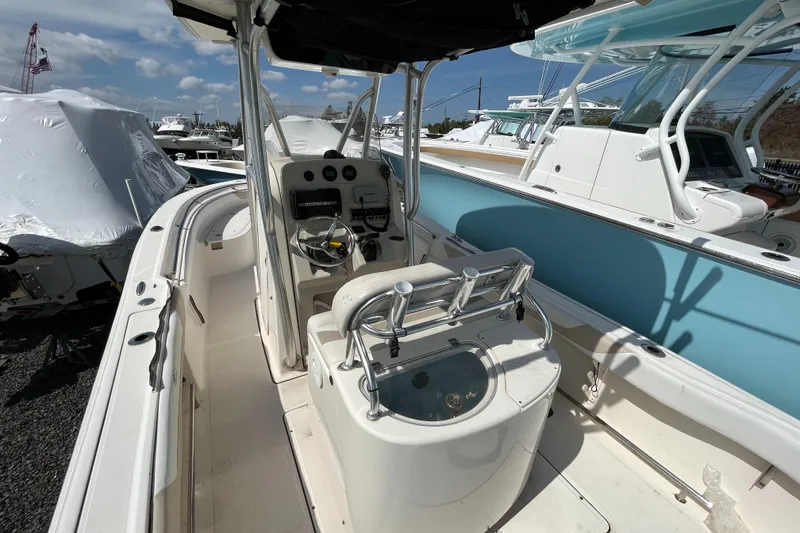 Slide: The Image of 2011 Pioneer 222 Sportfish boat with center console and seating, docked under clear skies. - 6
