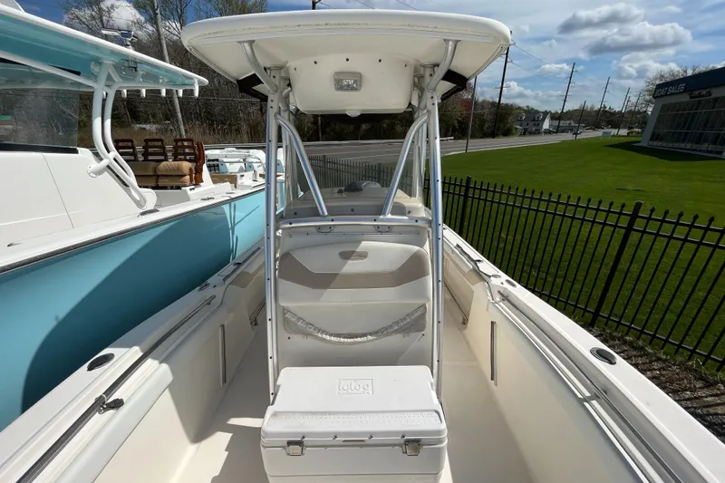 Slide: The Image of 2011 Pioneer 222 Sportfish boat with T-top and seating, docked outdoors. - 9