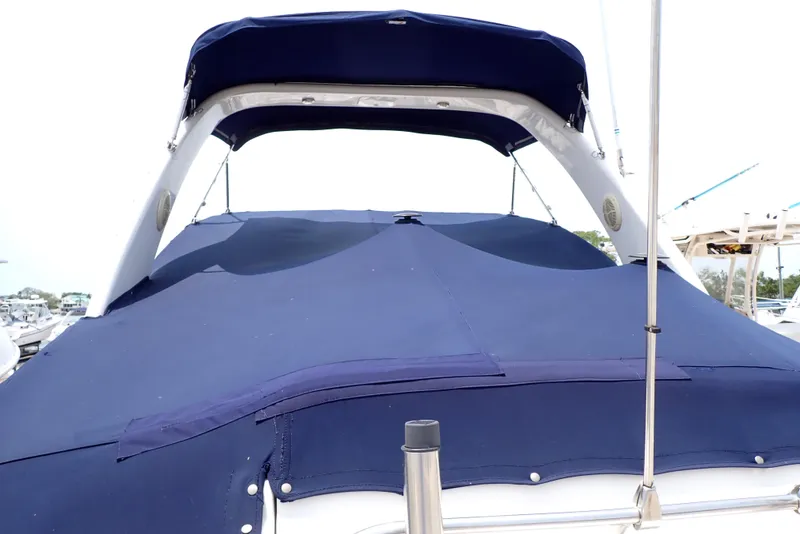 Slide: The Image of 2005 Monterey 270 Cruiser with blue canvas cover, docked at marina. - 12
