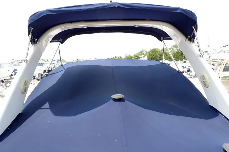 Slide: The Image of 2005 Monterey 270 Cruiser with blue canopy, docked at marina. - 13