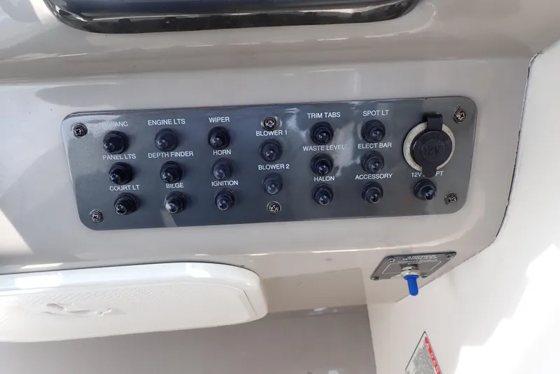 Slide: The Image of Control panel of a 2005 Monterey 270 Cruiser boat with various switches and a 12V outlet. - 19