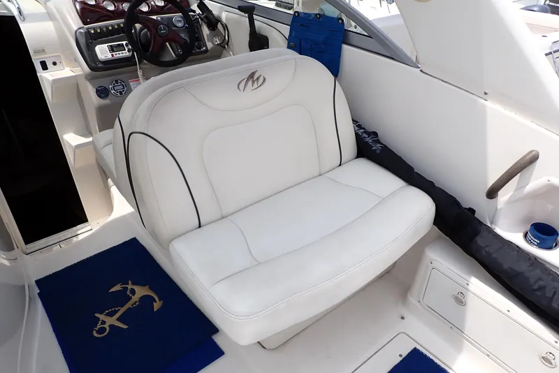 Slide: The Image of 2005 Monterey 270 Cruiser interior with white seating and nautical-themed decor. - 23