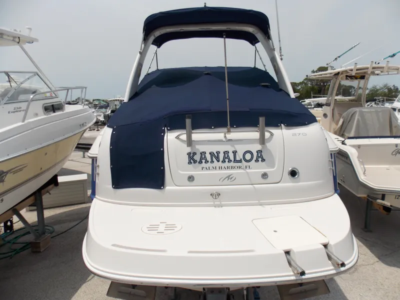 Slide: The Image of 2005 Monterey 270 Cruiser boat docked, rear view with blue cover. - 3