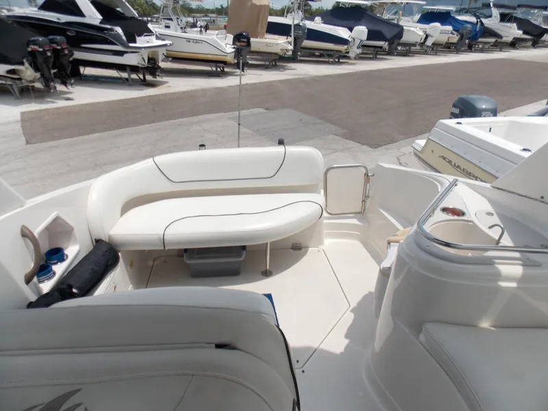 Slide: The Image of 2005 Monterey 270 Cruiser boat interior with white seating, docked among other boats. - 5