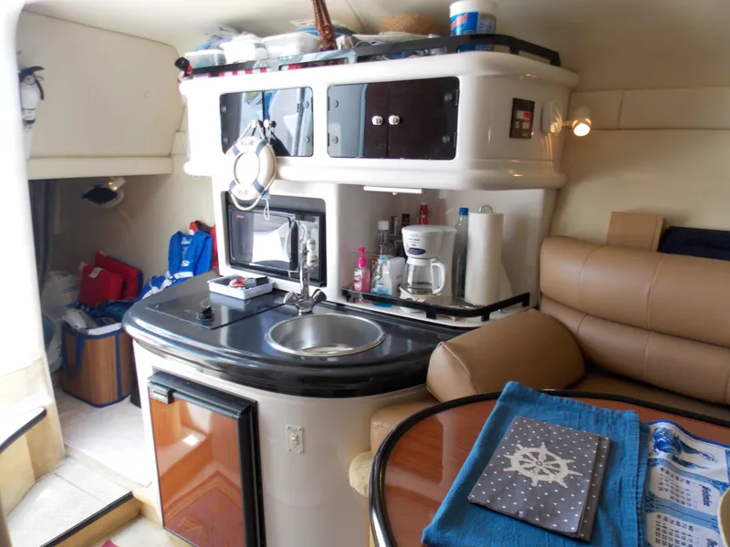 Slide: The Image of Interior of a 2005 Monterey 270 Cruiser boat with kitchenette and seating area. - 8