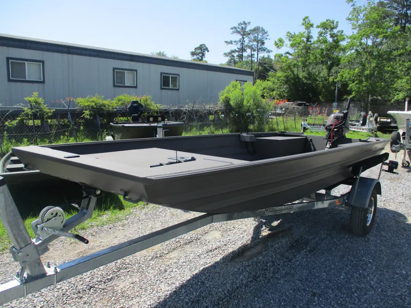 Slide: The Image of 2025 Alweld 1548 Marsh boat on trailer, parked outdoors near a building. - 1