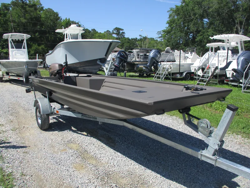 Slide: The Image of 2025 Alweld 1548 Marsh boat on trailer, parked outdoors with other boats. - 3