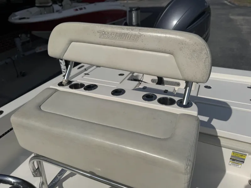 Slide: The Image of 2014 Pathfinder 2200 TRS boat seat with rod holders and engine in background. - 11