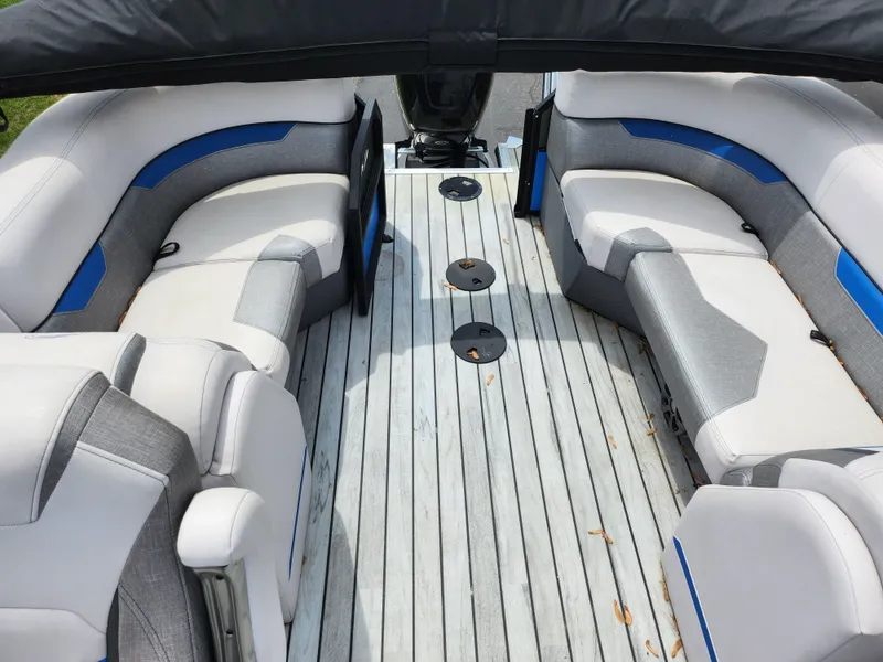 Slide: The Image of 2017 Crest Caliber 230 SLC boat interior with gray and blue seating, wooden deck. - 15