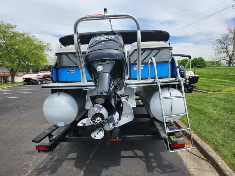 Slide: The Image of 2017 Crest Caliber 230 SLC pontoon boat with outboard motor, parked on a trailer. - 2