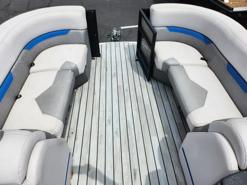 Slide: The Image of 2017 Crest Caliber 230 SLC boat interior with gray and blue seating on wooden deck. - 21