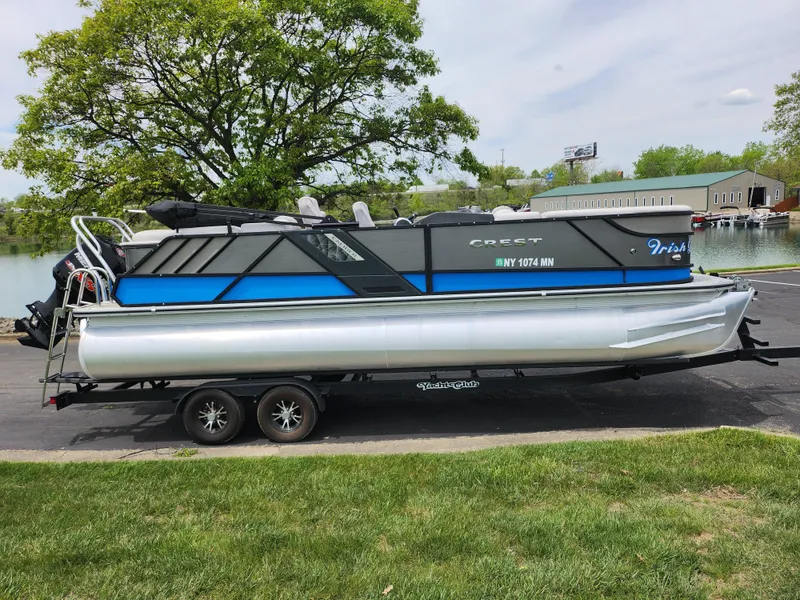 Slide: The Image of 2017 Crest Caliber 230 SLC pontoon boat on trailer, parked near a lake. - 9