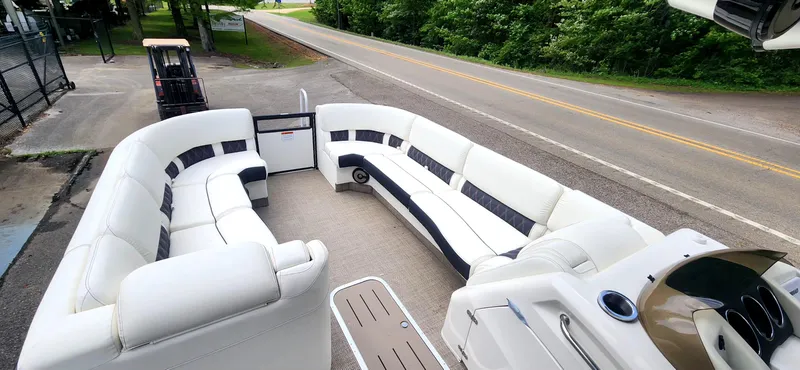 Slide: The Image of 2020 Bennington R 25 RSBA pontoon boat with spacious seating, parked near a road. - 10