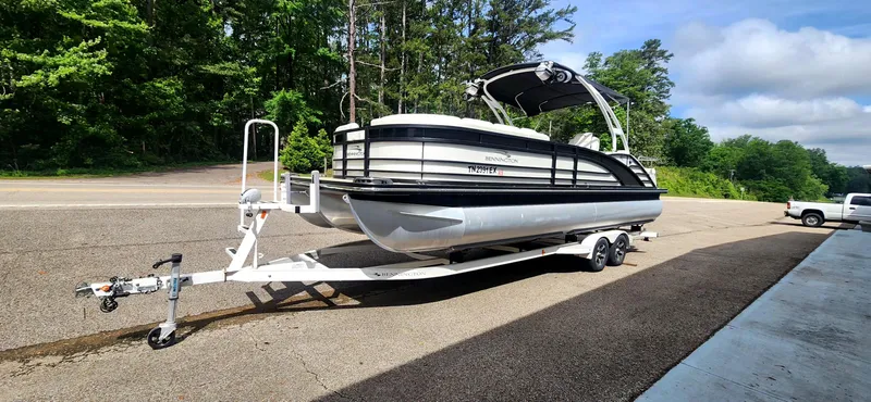Slide: The Image of 2020 Bennington R 25 RSBA pontoon boat on trailer, parked outdoors. - 6