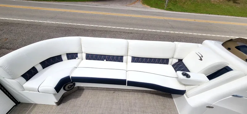 Slide: The Image of 2020 Bennington R 25 RSBA boat with white and navy seating on a road. - 8