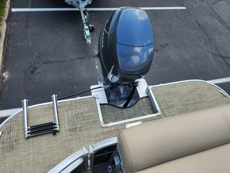 Slide: The Image of 2016 SunCatcher V20 Fish & Cruise boat with outboard motor and ladder, parked on asphalt. - 15