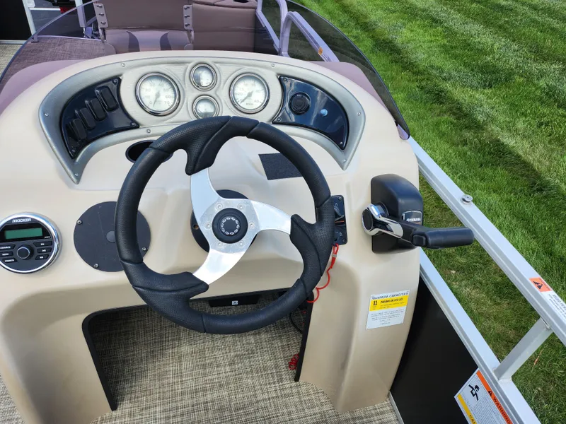 Slide: The Image of 2016 SunCatcher V20 Fish & Cruise boat dashboard with steering wheel and controls. - 19