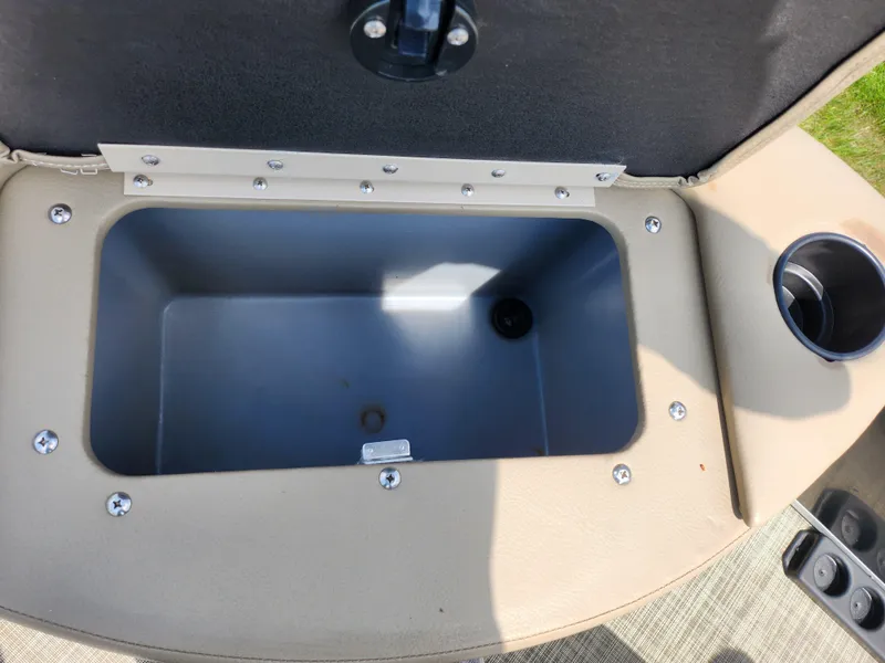 Slide: The Image of 2016 SunCatcher V20 Fish & Cruise storage compartment with cup holder, open lid view. - 24