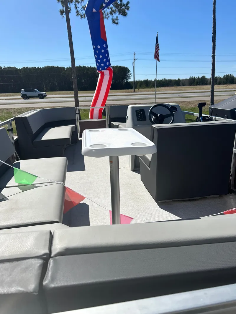 Slide: The Image of 2025 Custom Maui 210 Cruise boat with seating, table, and patriotic decor. - 10