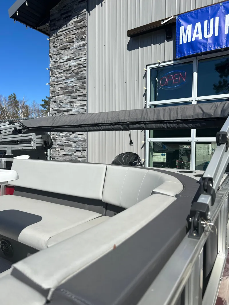 Slide: The Image of 2025 Custom Maui 210 Cruise boat with sleek seating, displayed outside a showroom. - 5