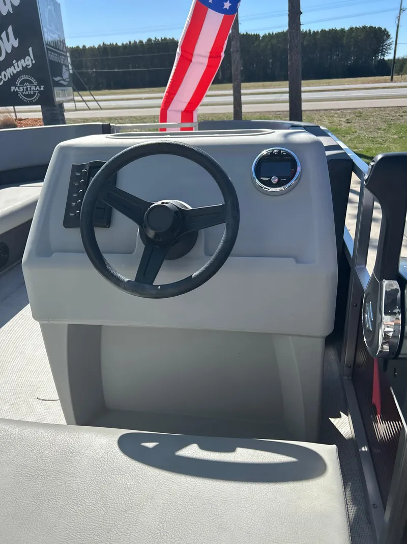 Slide: The Image of Steering console of 2025 Custom Maui 210 Cruise boat with American flag in background. - 9