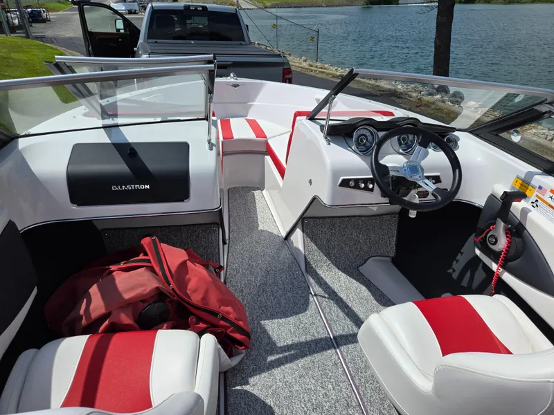 Slide: The Image of 2014 Glastron GT 185 boat interior with red and white seating, steering wheel, and dashboard. - 11