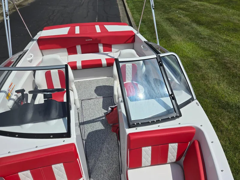 Slide: The Image of 2014 Glastron GT 185 boat interior with red and white seating, windshield, and steering wheel. - 19