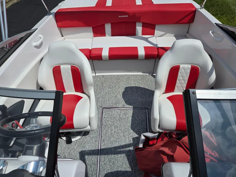 Slide: The Image of 2014 Glastron GT 185 boat interior with red and white seating and steering wheel. - 20