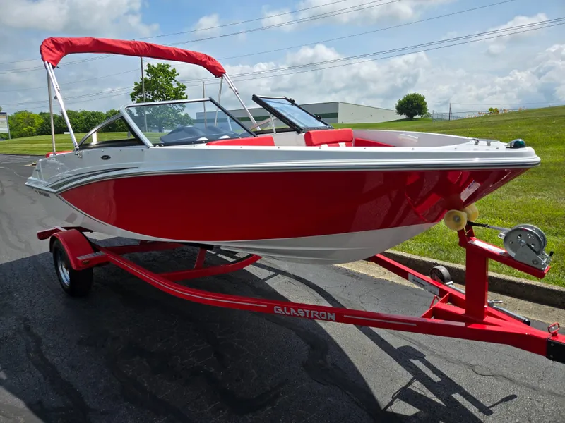 Slide: The Image of 2014 Glastron GT 185 boat with red hull and canopy on a matching trailer. - 5