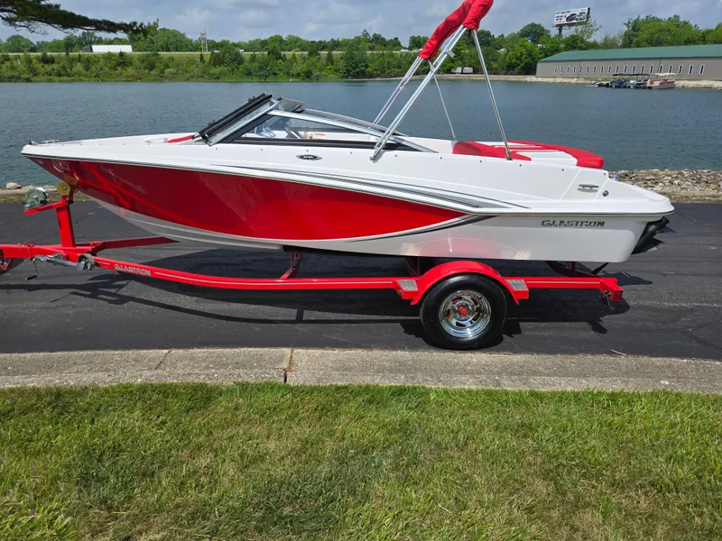 Slide: The Image of 2014 Glastron GT 185 boat on a red trailer by a lake. - 9