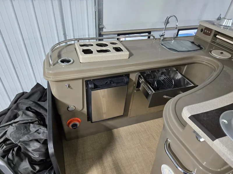 Slide: The Image of 2013 Premier 290 Grand Entertainer boat kitchen with sink, stove, and mini fridge. - 21