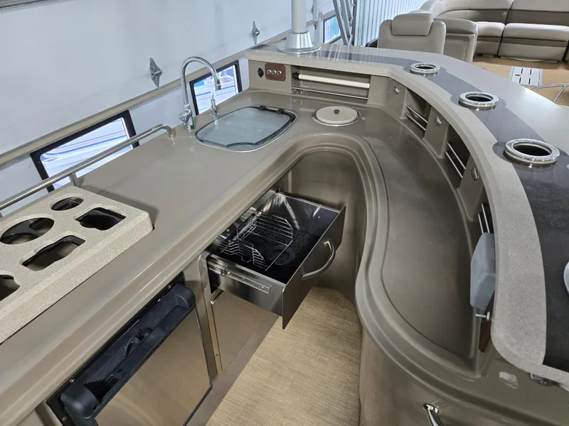 Slide: The Image of 2013 Premier 290 Grand Entertainer boat interior with kitchenette and seating area. - 22