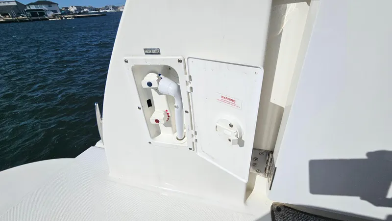 Slide: The Image of 2003 Sea Ray 410 Express Cruiser water hookup panel by the ocean. - 12